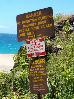 Three warning signs from state agencies near the Kalalau campground Three warning signs from state agencies near the Kalalau campground